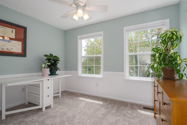 office space with baseboards, ceiling fan, visible vents, and light carpet