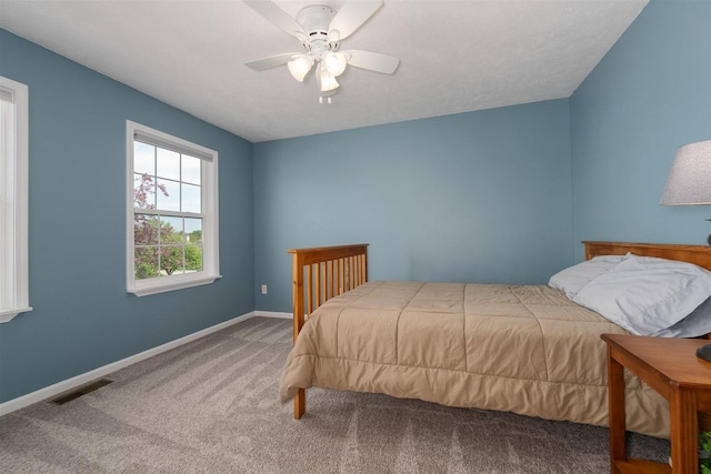 carpeted bedroom featuring baseboards, ceiling fan, and visible vents