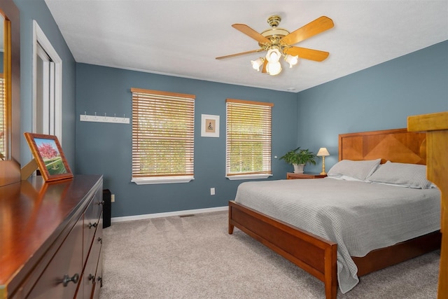 bedroom featuring a ceiling fan, baseboards, and light colored carpet