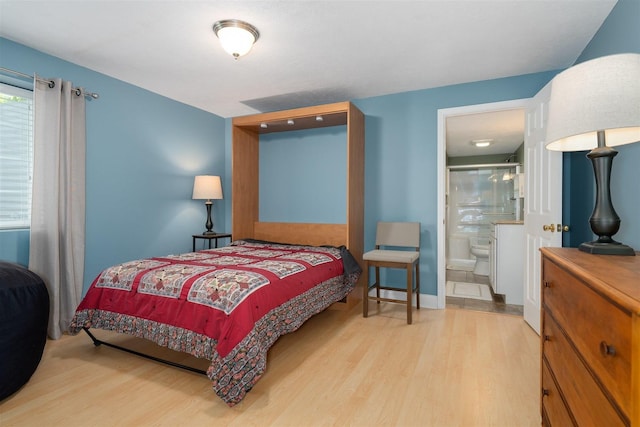 bedroom with ensuite bathroom and wood finished floors