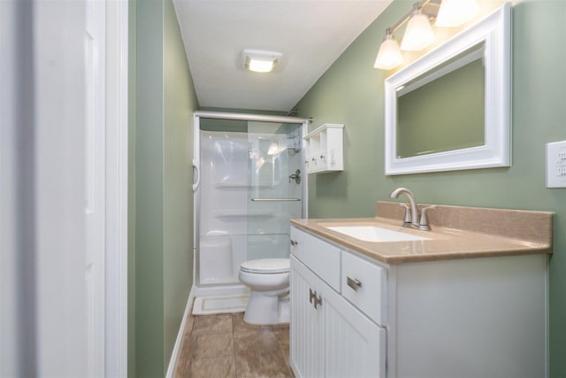 full bath with toilet, baseboards, a shower stall, and vanity