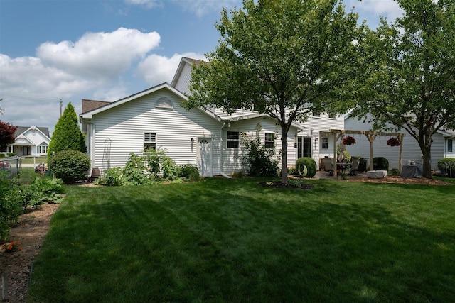 rear view of property featuring a patio and a yard