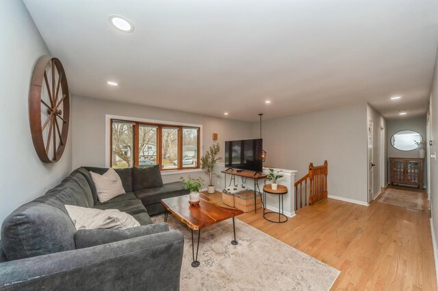 living area with baseboards, recessed lighting, and light wood-style flooring