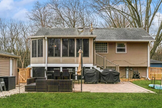 back of house with a lawn, a sunroom, a patio area, and a shingled roof