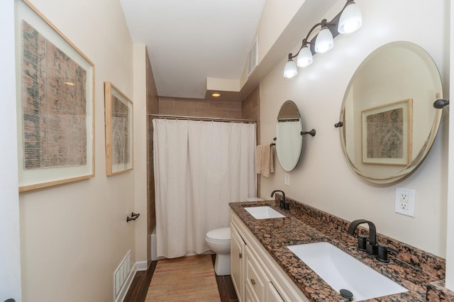 bathroom with wood finished floors, visible vents, a sink, and toilet