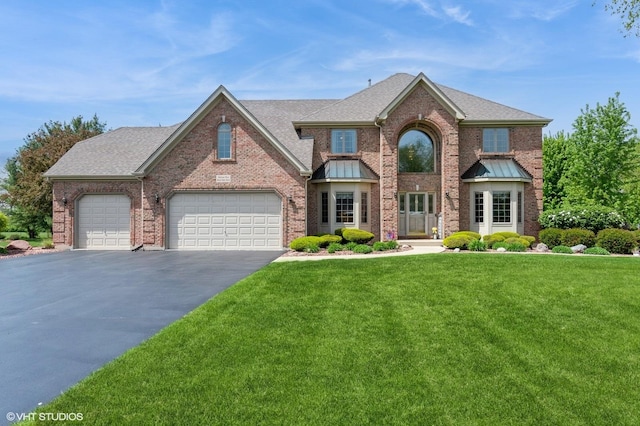 13 W Royal Oaks Dr, Bristol, IL 60512 - view of front facade featuring driveway, brick siding, a front yard, and an attached garage