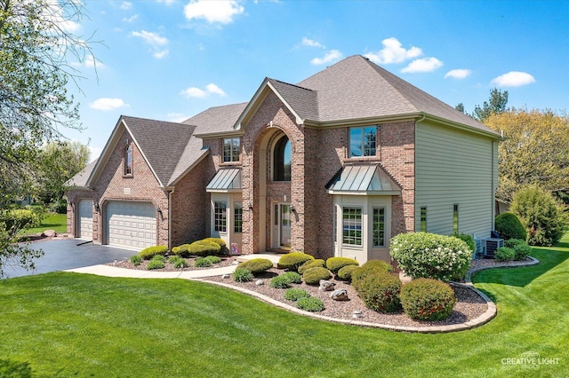 13 W Royal Oaks Dr, Bristol, IL 60512 - view of front of home featuring brick siding, driveway, central AC unit, a front yard, and a shingled roof