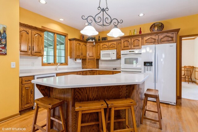 13 W Royal Oaks Dr, Bristol, IL 60512 - kitchen featuring white appliances, light countertops, light wood-style flooring, brown cabinetry, and recessed lighting