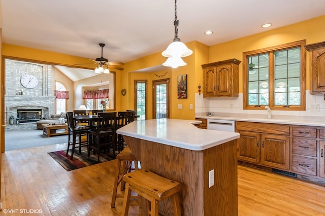 13 W Royal Oaks Dr, Bristol, IL 60512 - kitchen with light wood-style floors, brown cabinetry, a center island, healthy amount of natural light, and recessed lighting