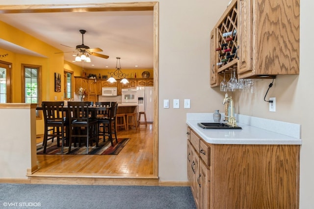13 W Royal Oaks Dr, Bristol, IL 60512 - indoor bar with white appliances, ceiling fan, baseboards, hanging light fixtures, and light wood-style floors
