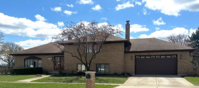 view of front of home featuring driveway, a chimney, brick siding, an attached garage, and a front yard