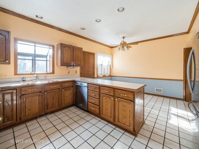 kitchen featuring stainless steel appliances, a peninsula, a sink, brown cabinets, and ornamental molding
