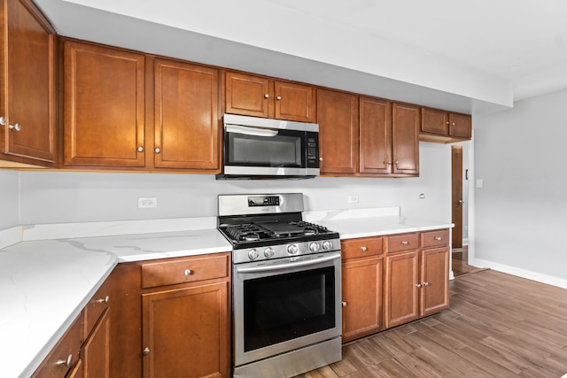 17148 William St, Lansing, IL 60438 - kitchen with baseboards, brown cabinetry, appliances with stainless steel finishes, and light wood-style flooring