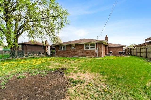 17148 William St, Lansing, IL 60438 - rear view of property featuring a chimney, brick siding, a fenced backyard, and a yard