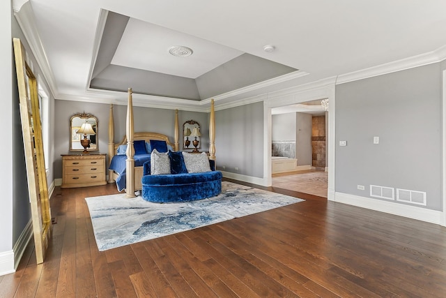 bedroom with a tray ceiling, baseboards, wood-type flooring, and crown molding