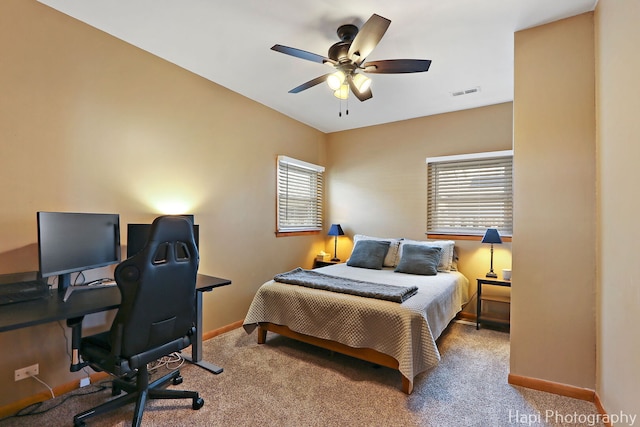 carpeted bedroom featuring visible vents, baseboards, and multiple windows
