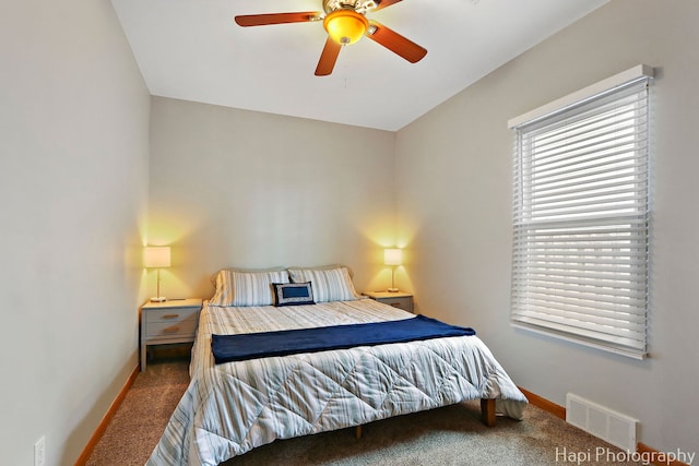 carpeted bedroom with visible vents, ceiling fan, and baseboards