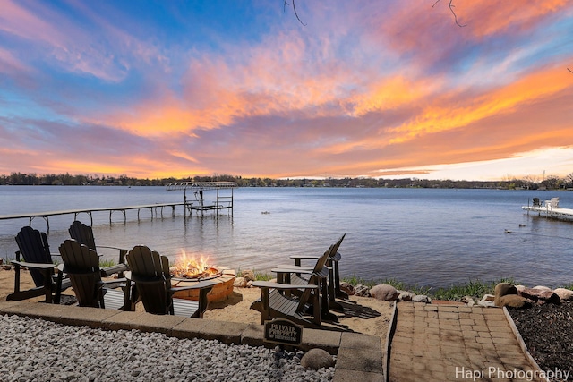 view of dock featuring a water view and an outdoor fire pit