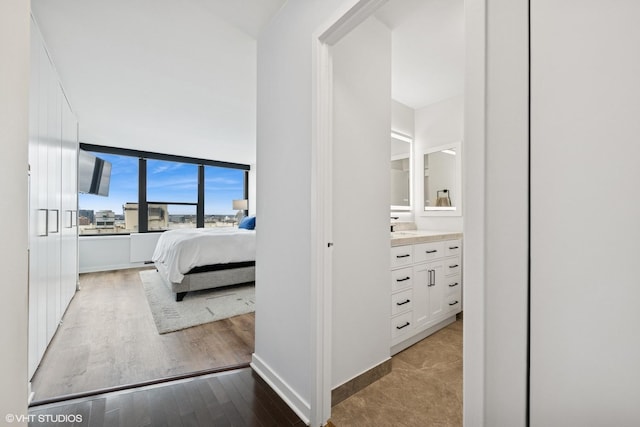 1560 N Sandburg Ter Unit 2301J, Chicago, IL 60610 - bedroom with wood finished floors, ensuite bathroom, and baseboards