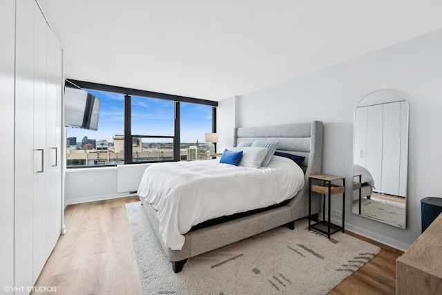 1560 N Sandburg Ter Unit 2301J, Chicago, IL 60610 - bedroom with baseboards and light wood-style flooring
