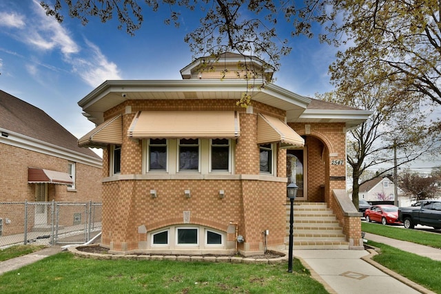 bungalow-style house with fence, brick siding, and a front yard