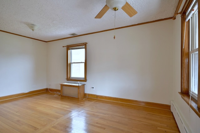spare room featuring a baseboard heating unit, crown molding, light wood-style floors, and a textured ceiling