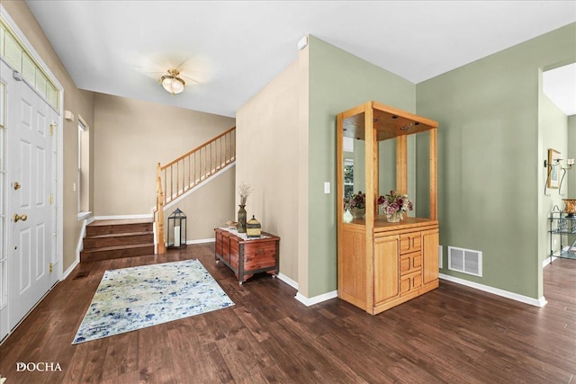 entrance foyer featuring visible vents, baseboards, stairs, and wood finished floors
