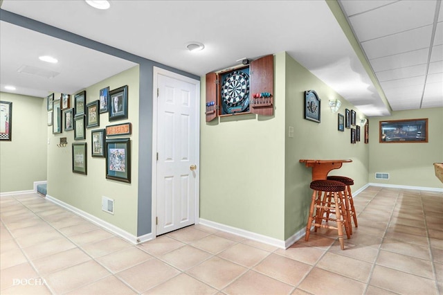 hallway featuring baseboards, recessed lighting, light tile patterned flooring, and visible vents