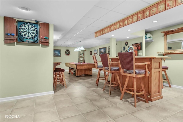bar with baseboards, indoor bar, a paneled ceiling, billiards, and light tile patterned floors