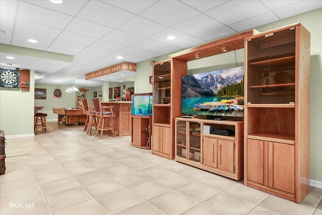 living room featuring indoor bar, recessed lighting, baseboards, and a drop ceiling
