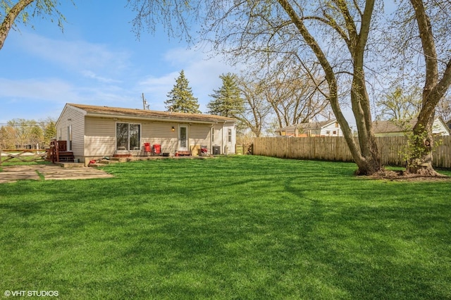 back of property with a yard, a patio area, and fence