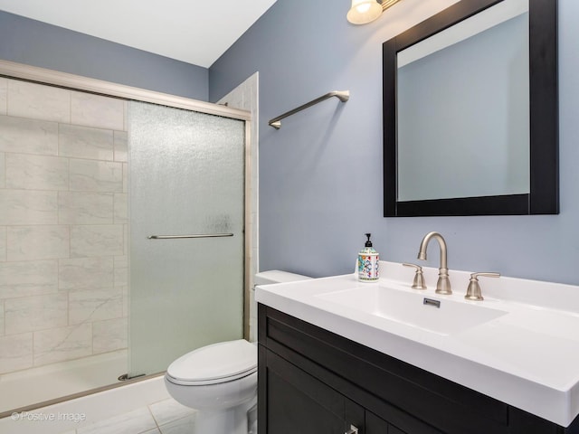 bathroom with toilet, vanity, and a stall shower