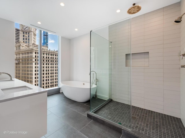 403 N Wabash Ave Unit 13B, Chicago, IL 60611 - bathroom with a stall shower, a soaking tub, vanity, expansive windows, and recessed lighting