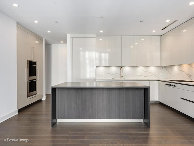 403 N Wabash Ave Unit 13B, Chicago, IL 60611 - kitchen with modern cabinets, white cabinets, stainless steel double oven, dark wood-style flooring, and recessed lighting