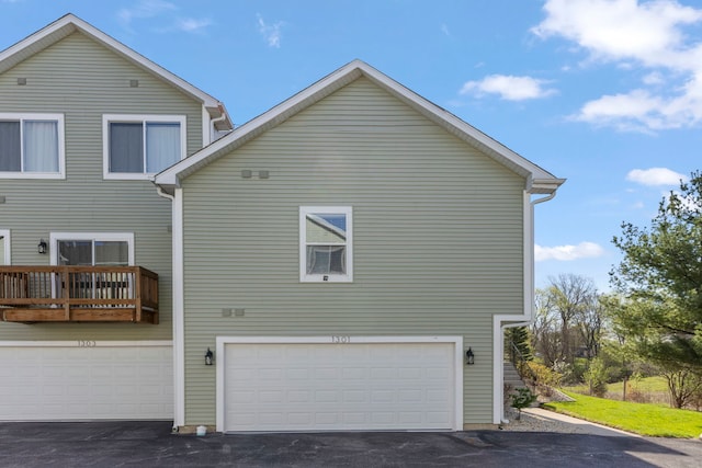 view of side of home with an attached garage and driveway