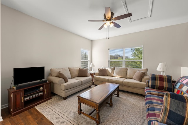 living area featuring attic access, dark wood finished floors, and ceiling fan