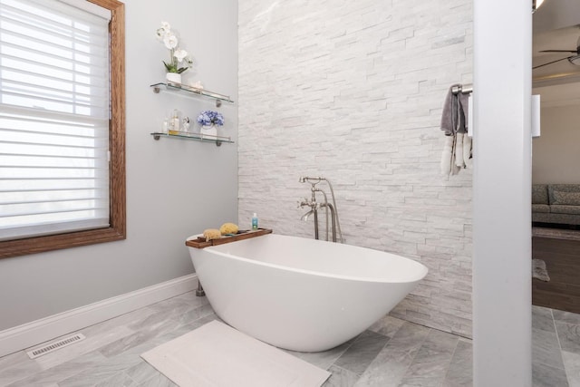 14431 E 2400 N Rd, Hudson, IL 61748 - full bathroom with a soaking tub, baseboards, marble finish flooring, and a ceiling fan