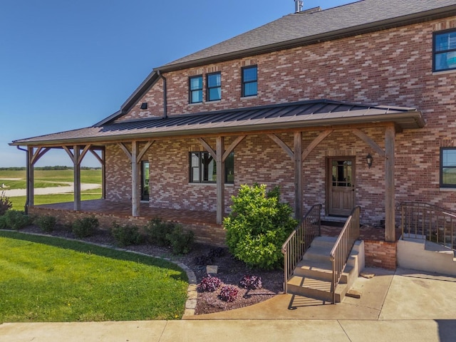 14431 E 2400 N Rd, Hudson, IL 61748 - view of front of house featuring brick siding, a front lawn, and a standing seam roof