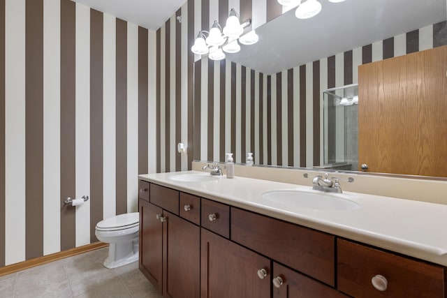 bathroom featuring a sink, a shower with shower door, toilet, tile patterned floors, and wallpapered walls