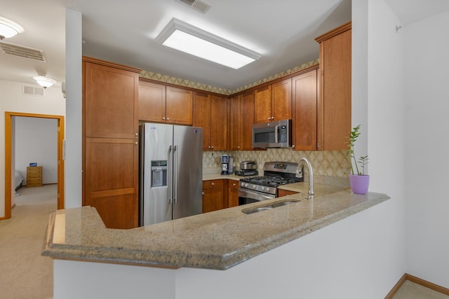 kitchen featuring backsplash, light stone counters, visible vents, and appliances with stainless steel finishes