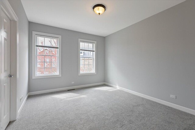 empty room with baseboards, carpet flooring, and visible vents
