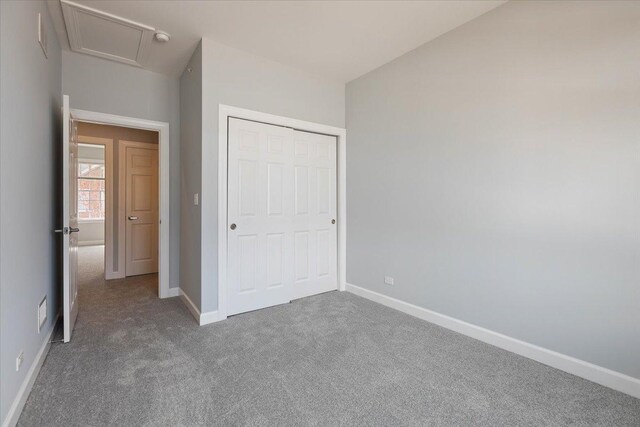 unfurnished bedroom featuring a closet, carpet, visible vents, and baseboards