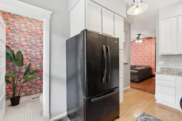kitchen featuring baseboards, white cabinets, freestanding refrigerator, light wood-style floors, and wallpapered walls