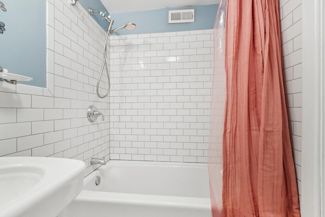 full bath featuring tile walls, visible vents, and shower / tub combo