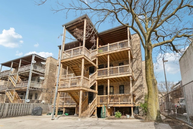view of building exterior with stairs and fence