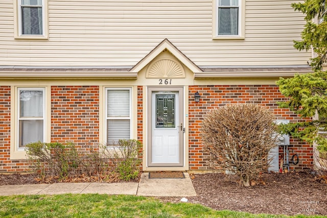 doorway to property with brick siding