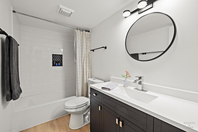 bathroom featuring toilet, visible vents, shower / tub combo with curtain, wood finished floors, and vanity