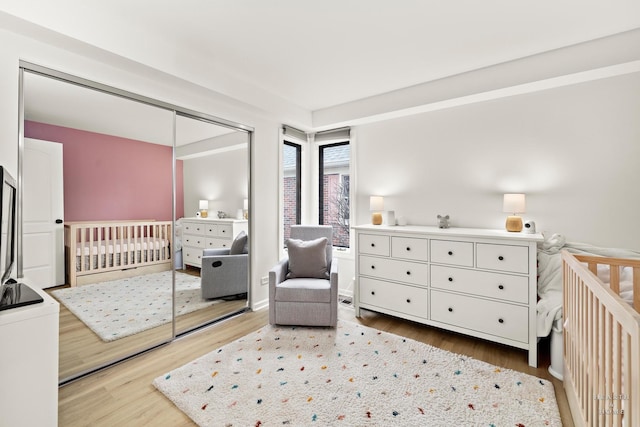bedroom featuring wood finished floors and a nursery area