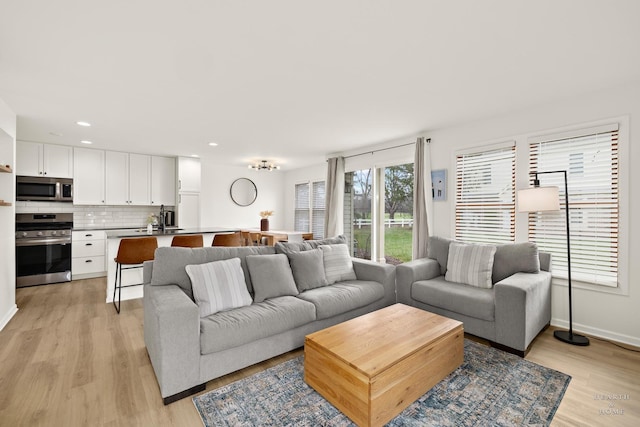 living room featuring recessed lighting, light wood-type flooring, and baseboards