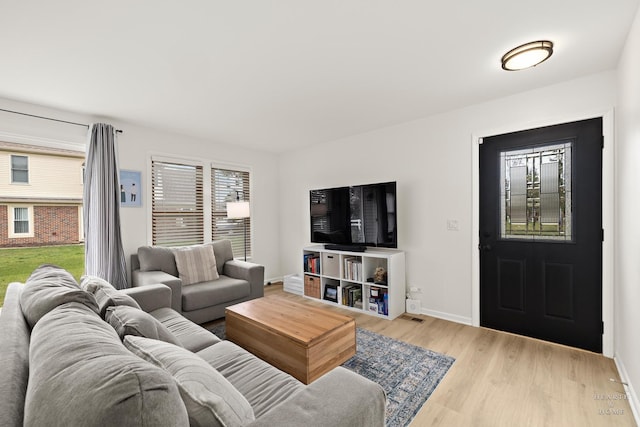 living area with wood finished floors, baseboards, and plenty of natural light